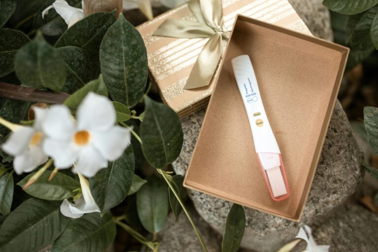 Positive pregnancy test in a wooden bo on top of flowers | First baby appointment | Mary's Refuge | Martinsburg, WV