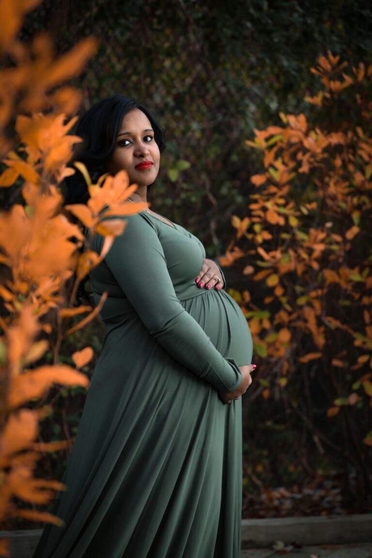 Pregnant woman in dark green dress holding her stomach | 6 Week Baby Development | Mary's Refuge, Martinsburg WV