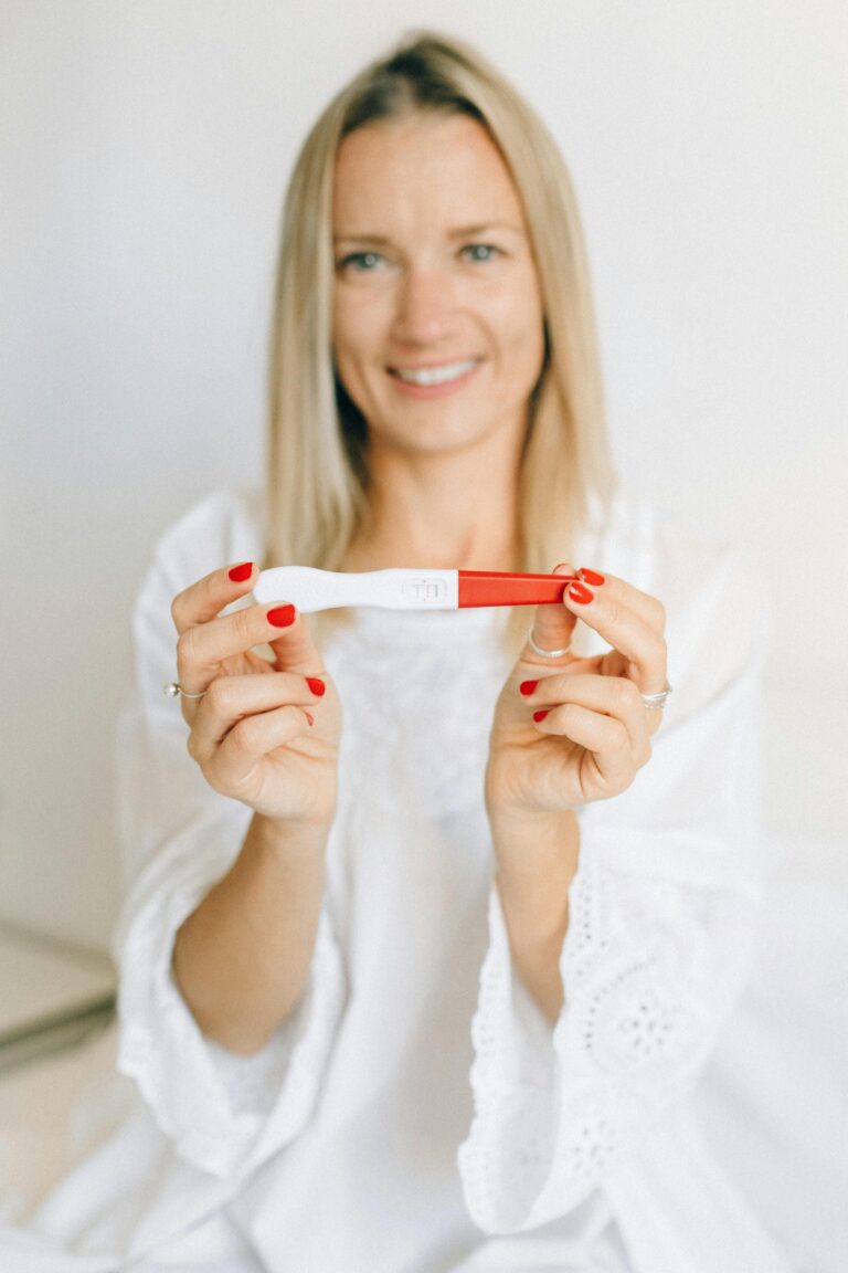 Women smiling and holding up a positive pregnancy test | Positive Pregnancy Test | Mary's Refuge, Martinsburg WV