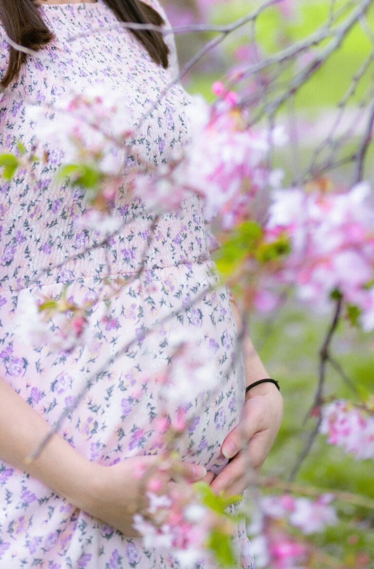 a pregnant woman standing in a field of flowers | Unplanned Pregnancy | Mary's Refuge, Martinsburg, WV