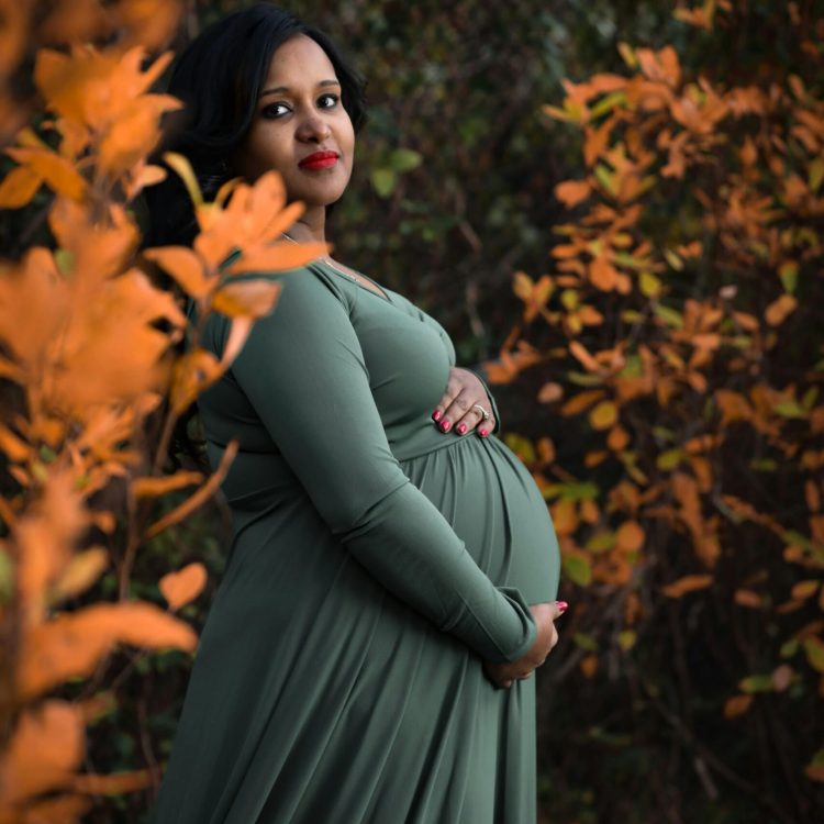 Pregnant woman in dark green dress holding her stomach | 6 Week Baby Development | Mary's Refuge, Martinsburg WV