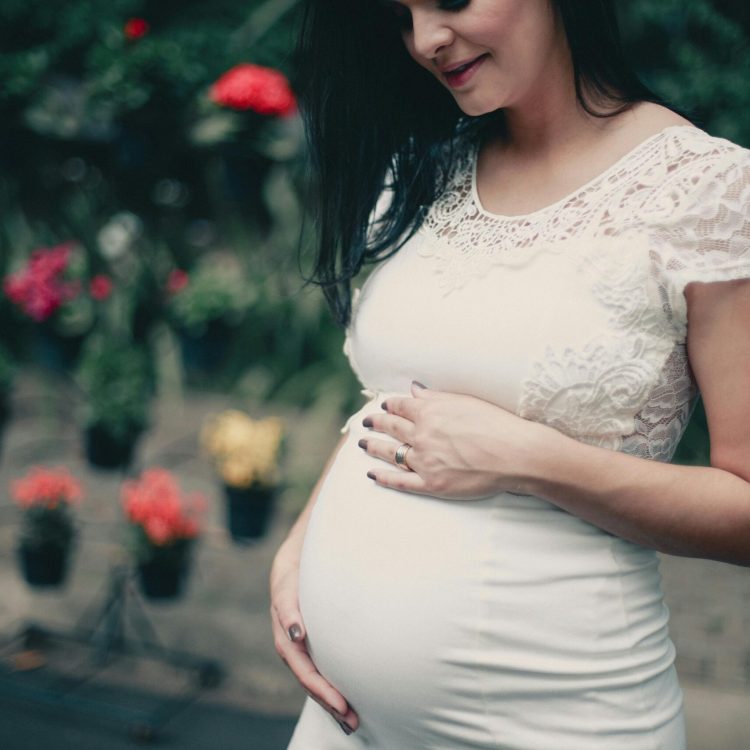 pregnant women holding her belly and smiling