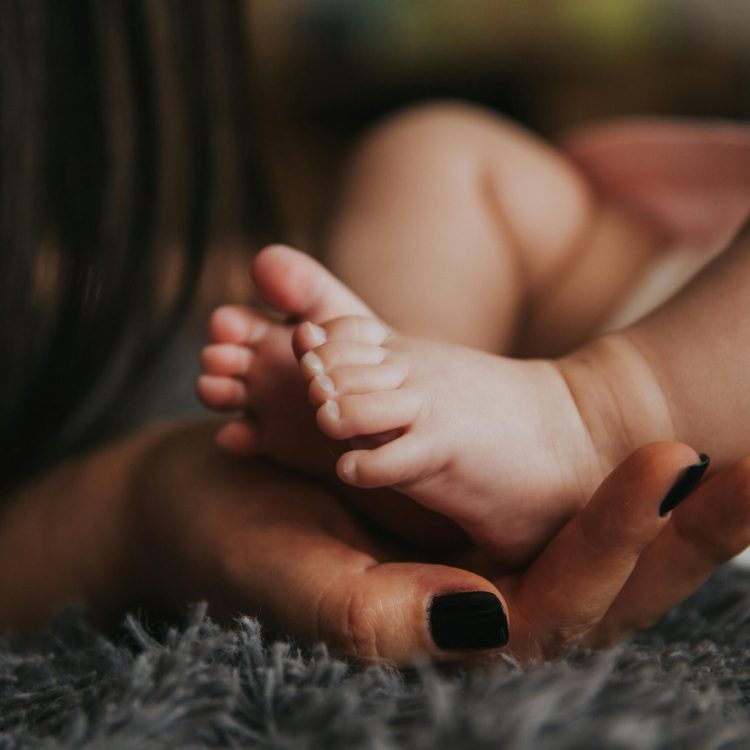Baby feet in the palm of mother's hand | Benefits of Prenatal Vitamins | Mary's Refuge | Martinsburg WV