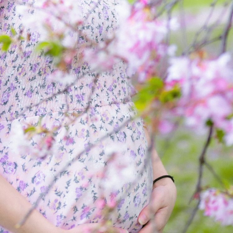 a pregnant woman standing in a field of flowers | Unplanned Pregnancy | Mary's Refuge, Martinsburg, WV